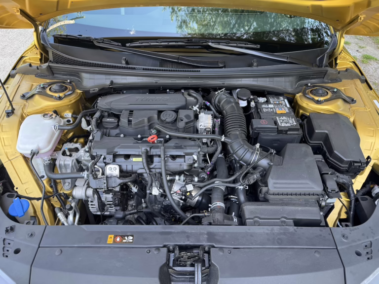 2026 Kia K4 hatchback GT Line Turbo, sparkling yellow, engine bay. Image by Robin Warner